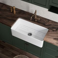 a large white sink sitting on top of a wooden counter next to green cupboards