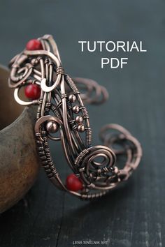 an intricate wirework ring with red beads on it