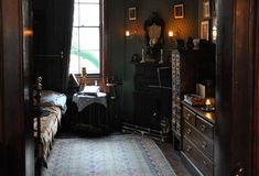 an old fashioned bedroom with dark wood furniture and green walls, decorated in antique style