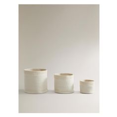 three white vases sitting next to each other