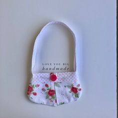 a white purse with red flowers and a message on it