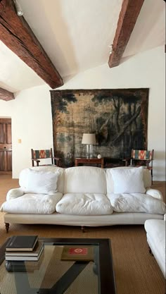 a living room filled with furniture and a painting on the wall