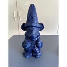 a blue figurine sitting on top of a table next to a white cupboard