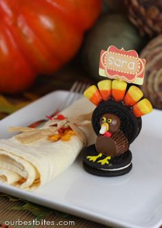 a white plate topped with a turkey on top of a napkin