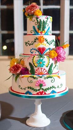 a multi - tiered cake decorated with flowers on a table