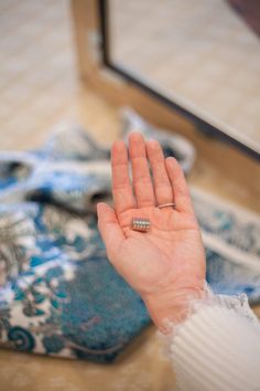 a person holding their hand up in front of a mirror with the ring on it