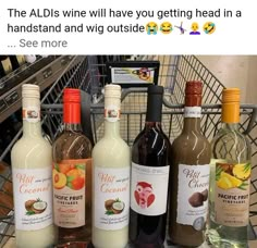 bottles of wine sitting on top of a counter next to a shopping cart in a store