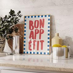 a sign that says bon appe ett on it next to some cups and vases