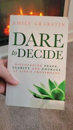 Book Dare To Decide by Emily Garabatin held in from of an electric fireplace. Emily Collins, Crossroads In Life, Book Club Reads, Aspiring Author, Fear Of The Unknown, Into The Unknown, Pinterest Ideas, Avid Reader, Wonderful Words