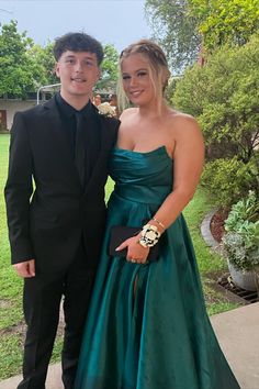 a young man and woman in formal wear posing for a photo together at an event