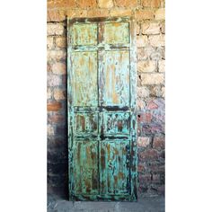 an old green door sitting next to a brick wall