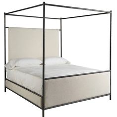 an iron bed frame with white linens and pillows on the bottom, against a white background