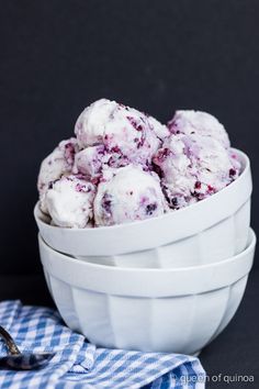 a white bowl filled with blueberry muffins on top of a checkered table cloth