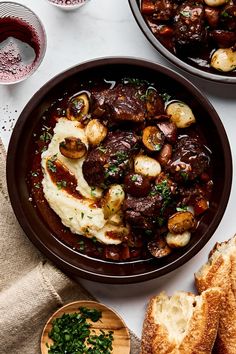 two brown bowls filled with food next to bread