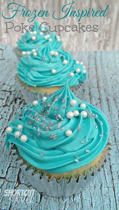 two cupcakes with blue frosting and white sprinkles on top