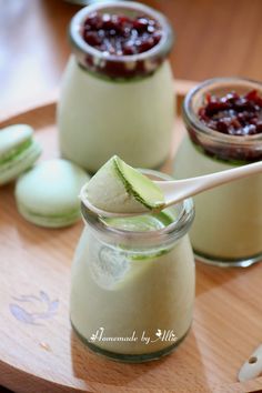 two jars filled with cucumber and jam on top of a wooden tray