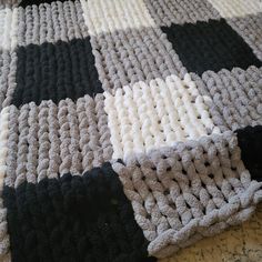 a crocheted blanket with black and white squares