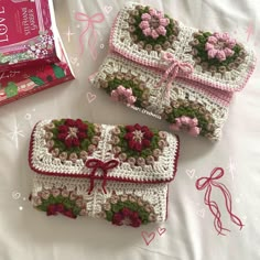 two crocheted purses sitting on top of a bed next to a candy bar