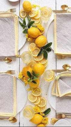 the table is set with lemons and white plates