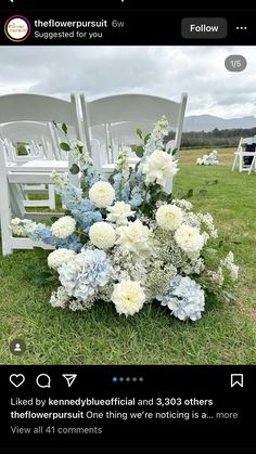 a bouquet of blue and white flowers sitting on top of a chair in the grass