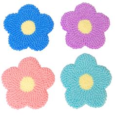 four different colored flower shaped rugs on a white surface with one blue, one pink and one purple