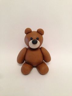 a brown teddy bear sitting on top of a white table