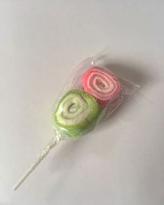 two lollipops wrapped in cellophane on a white surface