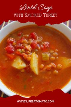 a white bowl filled with soup next to a red and white striped table cloth on top of a wooden table