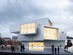 people are standing in front of a white building with windows on the top and bottom floor