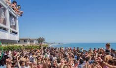 a large group of people standing on top of a beach