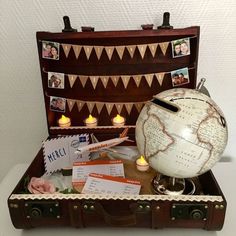 an open suitcase filled with travel items and pictures on the inside, including a globe