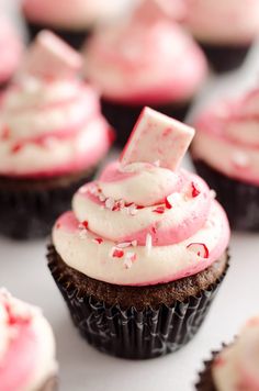 cupcakes with white frosting and red sprinkles on the top