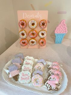 there are many decorated doughnuts on the table and in front of it is a sign that says donuts