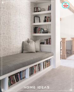 a book shelf filled with lots of books next to a white wall and window sill