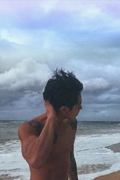 a man standing on the beach talking on his cell phone