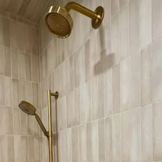 a shower head and hand shower in a tiled bathroom with beige tiles on the walls