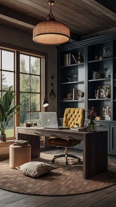 a desk with a laptop on top of it in front of a bookcase filled with books