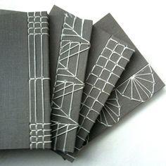 five gray notebooks with white lines on them