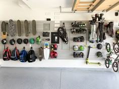 there are many skateboards and other items on the wall in this garage with hooks