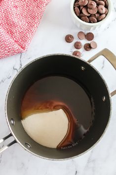 chocolate chips and milk in a saucepan on a marble counter