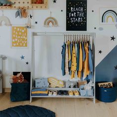 a child's room with clothes and toys hanging on the rack in front of it