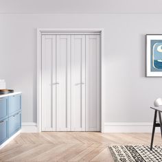 a white kitchen with blue cabinets and an art print hanging on the wall above it