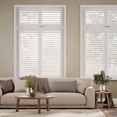 a living room filled with furniture and windows covered in white shutters on top of them