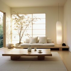 a living room filled with furniture next to a large glass window and a tree in the background