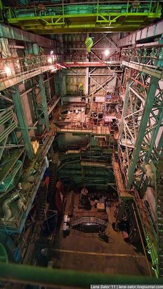 the inside of an industrial building with lots of pipes and machinery on it's sides