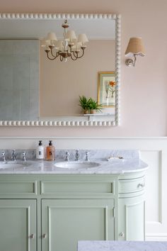 a bathroom with two sinks and a large mirror on the wall over it's vanity