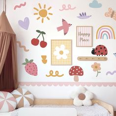 a child's room decorated in pink, white and yellow with lots of wall stickers