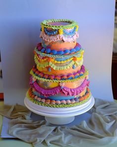 there is a multi layer cake on top of a plate with ruffles around the edges