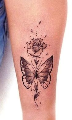 a woman's leg with a butterfly and rose tattoo on it