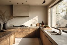 a kitchen with wooden cabinets and counter tops next to a large window that looks out onto the trees outside